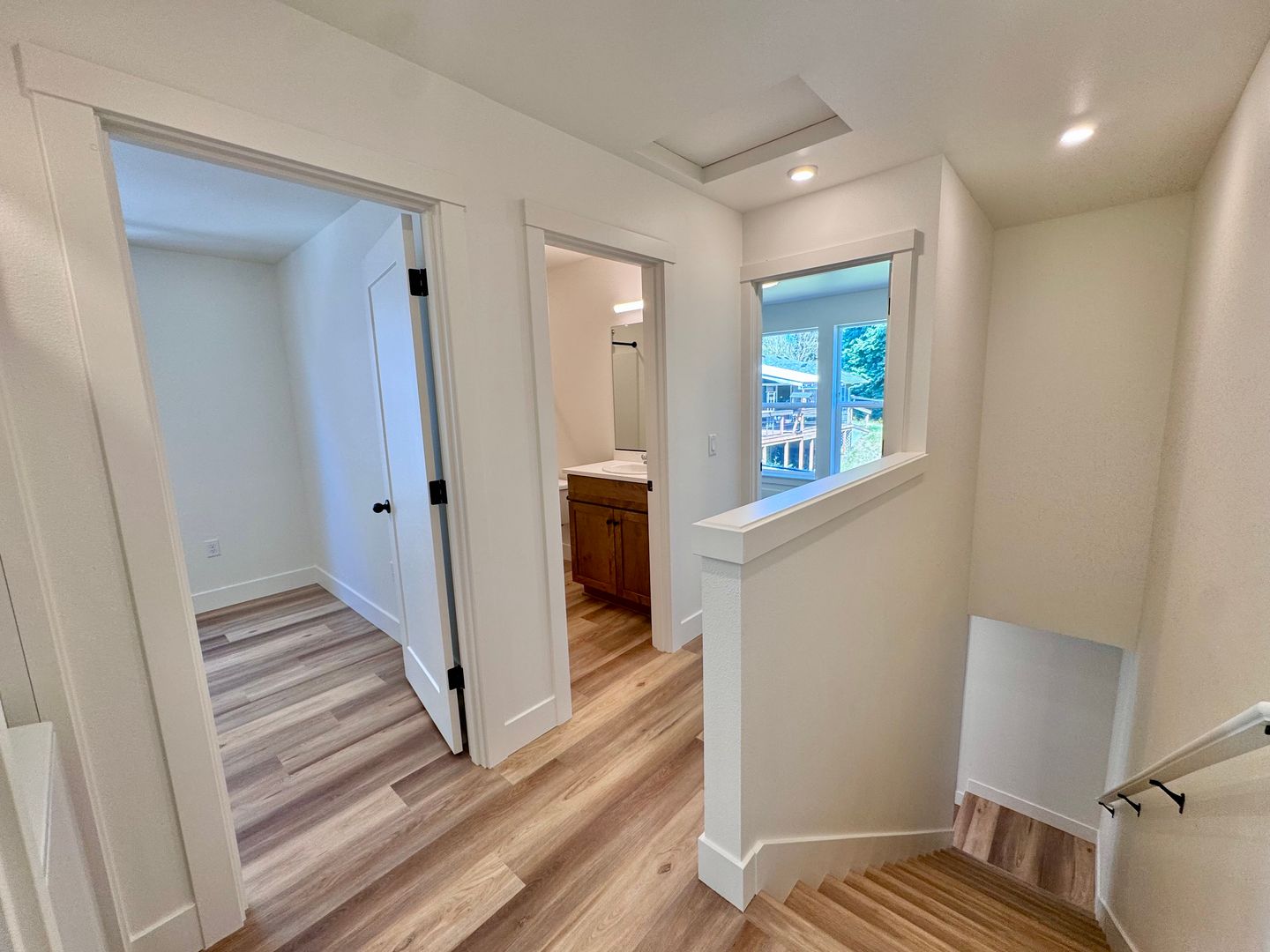 Upstairs landing leading to bedroom, full bathroom, and stairwell