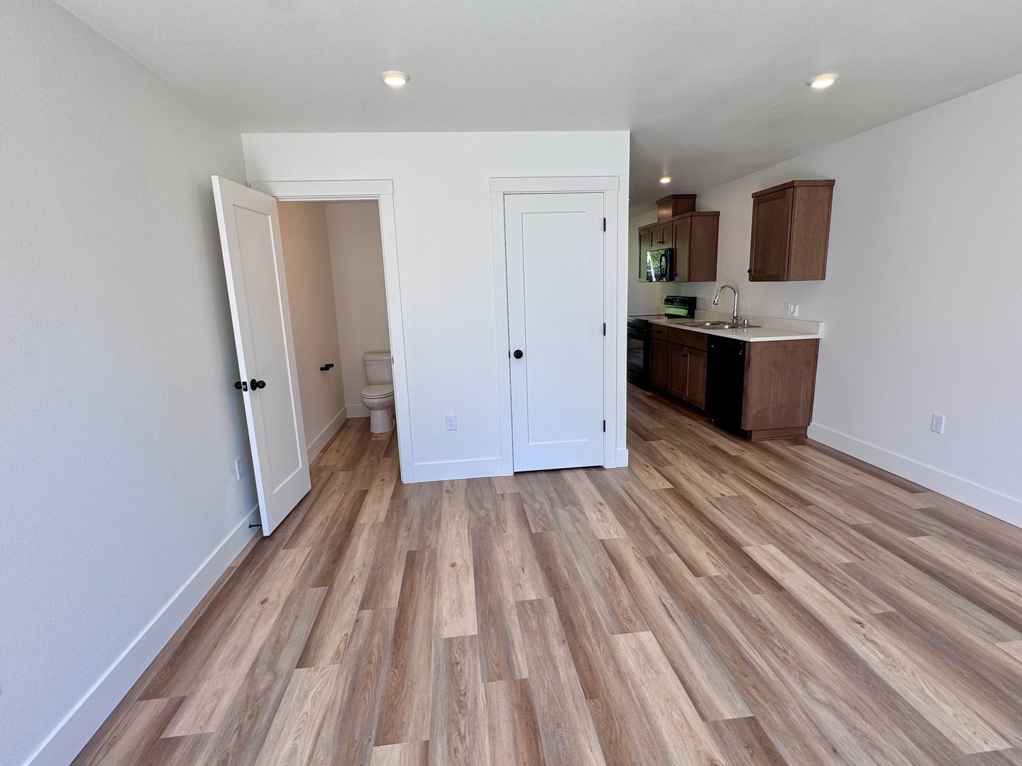 Open living area leading into the kitchen with wood cabinetry